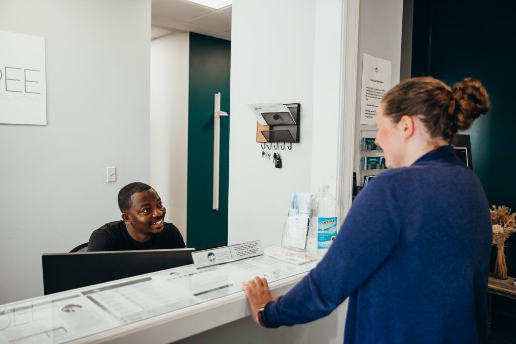 Big Tree Medical staff speaking with patient from across reception desk