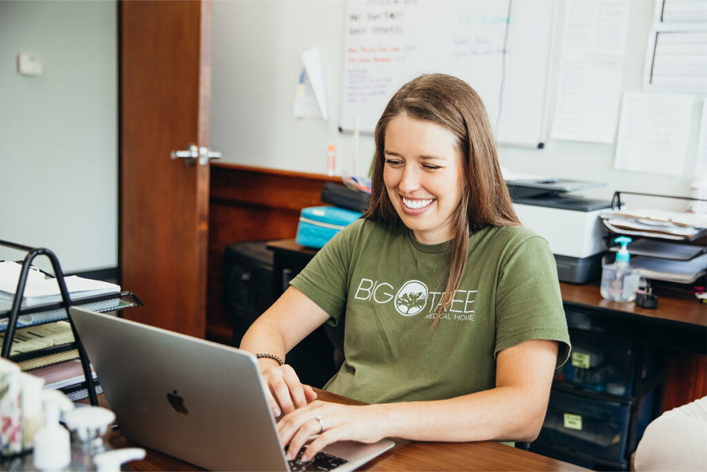 Big Tree Medical staffmember on laptop, smiling